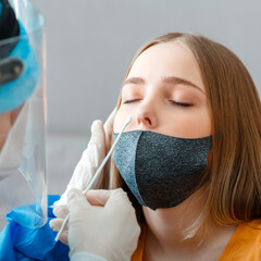 Diagnostics testing patients coronavirus covid 19. Doctor in protective medical mask taking PCR...