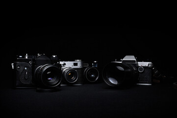 Four vintage film cameras on a dark background