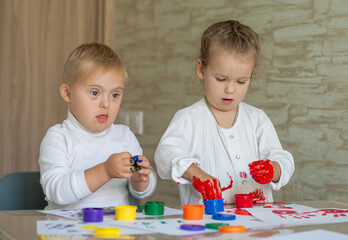 Little children paint with paints. The kids got their hands dirty in gouache. A cute girl and a boy...