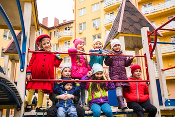 Cheerful kids at outdoor playground in early spring