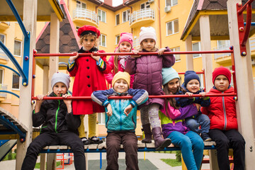 Cheerful kids at outdoor playground in early spring