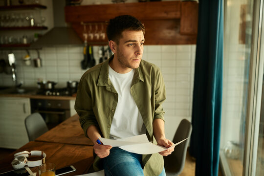 Pensive man going through paperwork while working at home.