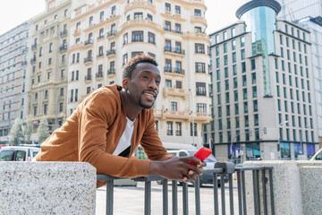 young african man in the city with his smartphone