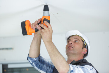 a man drills the ceiling