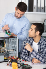 young apprentice repairing computer in technical school