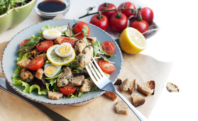Salad with mussels, tomatoes, eggs, arugula, spinach, basil, lemon and croutons on white background. Seafood salad with vine sauce. Mussels on fork