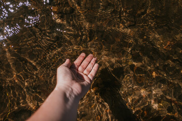 Hand submerged in the clear water of a lake in Patagonia Argentina