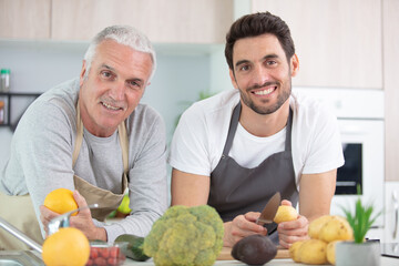 Fototapeta premium cheerful senior dad and happy son in the kitchen