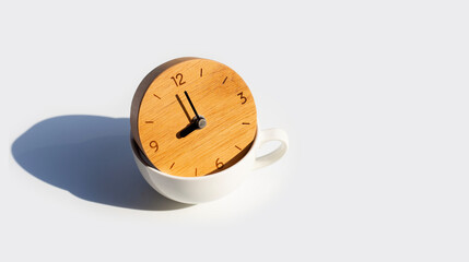 Wooden clock in white cup on white background.