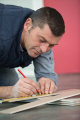 male woodworker hands using a pen to draw a line