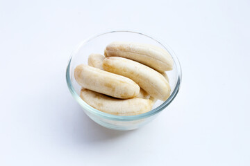 Peeled banana on glass bowl on white
