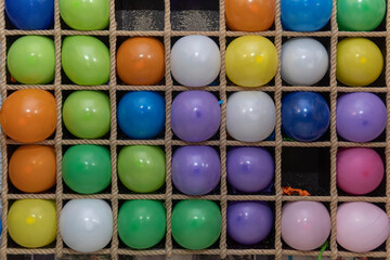 Inflatable multi-colored balls in the cells for playing darts, close up