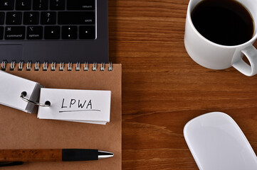 There's a cup of coffee, a laptop and a notebook with a word book on it that says LPWA. It was an...
