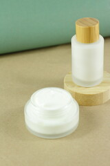 Moisturizing cream in eco-friendly bamboo jar. Natural organic cosmetic packaging design. Hand skin care concept.