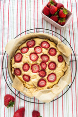 Strawberry cake on a metal cooling rack in vertical orientation.