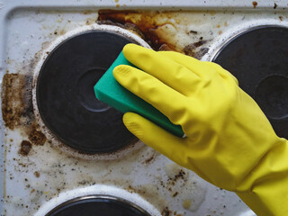 Hand in glove washing messy kitchen stove