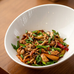 spicy Thai spaghetti with onions and sesame seeds. Food concept. Eastern cuisine. Square format or 1x1 for posting on social media.