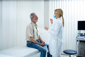 Obraz premium Old man taking nose or throat swab to get tested on corona virus.