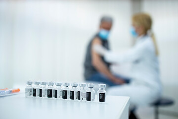 Immunization and vaccination of older population. Bottles with vaccine on the table.