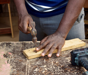 Black African carpenter working with carpentry  equipment in a  carpenter's workshop
