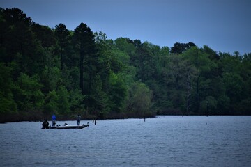 men fishing from boat on a lake in texas during a rain storm
