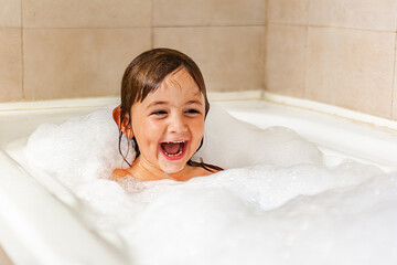 girl bathing playing with foam 
