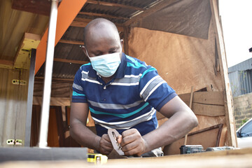 Black African carpenter working with carpentry  equipment in a  carpenter's workshop
