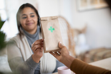 Woman reaching for prescription pharmacy bag