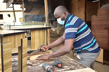 Black African carpenter working with carpentry  equipment in a  carpenter's workshop
