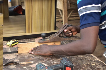Black African carpenter working with carpentry  equipment in a  carpenter's workshop
