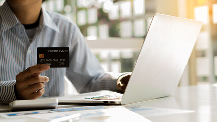 A man with a credit card and prints Online shopping on the internet using laptop and online payment ideas.