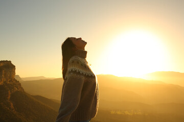 Profile of a woman breathing fresh air in nature at sunrise