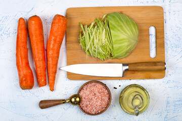 cabbage carrots and salt on a cutting board