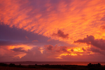 An impressive sunrise with the sky full of colorful clouds in nice formation and painting the ocean with red color. Iriomote Island.