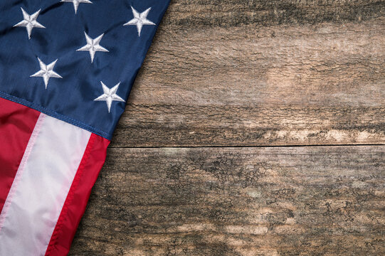 Flag of USA on natural wood table. United States of America. US patriotic symbol. American freedom and Independence. Background with copy space. Macro high resolution photo.