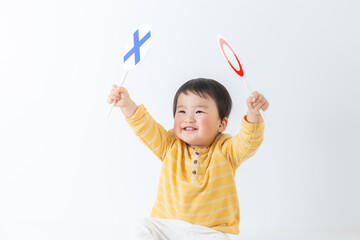 マルバツの札を上げる子供