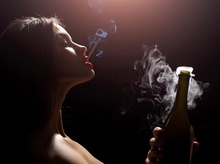 Closeup portrait of young sexy woman smoking cigarette in studio on black background