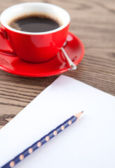 A cup of coffee and writing instruments