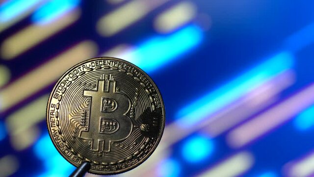 Golden bitcoin with moving bokeh diagonal neon multi coloured background. 