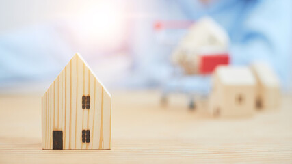 Wooden house model with blurred background. Housing investment ideas.