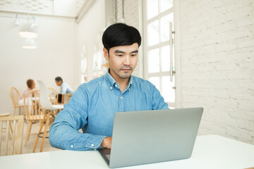 Fototapeta premium asian man work using computer hand typing laptop keyboard contact us.student study learning education online.adult professional people chatting search at office.concept for technology device business