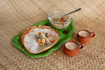 Appam, Hoppers and mutton stew Kerala breakfast food and Indian milk tea chai, christian breakfast India Sri Lanka Tamil Nadu fermented rice pan cake. Indian veg food.