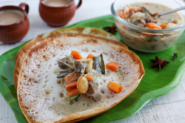 Appam, Hoppers and mutton stew Kerala breakfast food and Indian milk tea chai, christian breakfast India Sri Lanka Tamil Nadu fermented rice pan cake. Indian veg food.