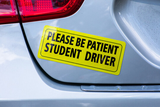 Please Be Patient Student Driver - yellow bumper sticker on the car.