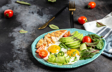 Healthy breakfast. Chicken grilled fillet with salad fresh tomatoes, cucumbers, eggs and avocado. Keto Paleo diet menu. top view