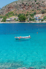 view of  Limeni village with fishing boats in  turquoise waters and the stone buildings as a background  in Mani, South Peloponnese , Greece.