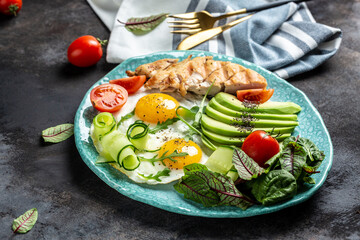 Chicken grilled fillet with salad fresh tomatoes, cucumbers, eggs and avocado. Healthy breakfast, ketogenic diet, diet lunch concept. place for text, top view