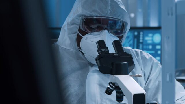 African-American doctor is doing a science experiments and developing vaccine in a modern laboratory. Genetic engineers workplace. The concept of science and medicine.