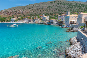 Fototapeta na wymiar view of Limeni village with fishing boats in turquoise waters and the stone buildings as a background in Mani, South Peloponnese , Greece.