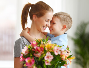 Happy woman and boy with flowers touching nose